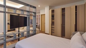 Une chambre à coucher avec un lit, une télévision, un bureau et une armoire.