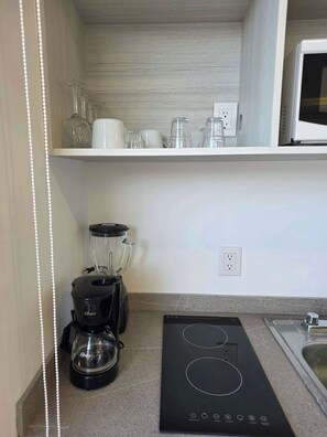 A compact kitchen with a built-in oven, a coffee maker, and a blender on the counter. - Modern 1-Bed Apartment in Miguel Hidalgo with Balcony (Ciudad de México)