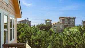 Un barrio residencial con varias casas, una terraza de madera y abundante vegetación.