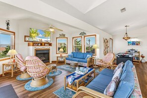 A spacious living room with a fireplace, comfortable seating, and large windows offering a view of the outdoors. - Only a 2 minute walk to the Avon beach! Private Pool, Hot Tub, Luggage Lift (Avon)