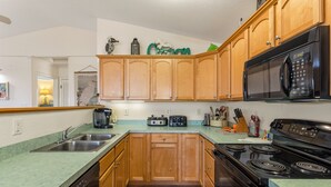 Una cocina con armarios de madera, un microondas, una estufa y un lavavajillas.