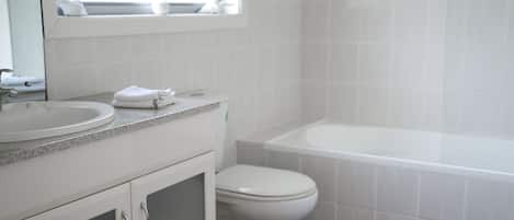 A bathroom with a sink, toilet, and bathtub.