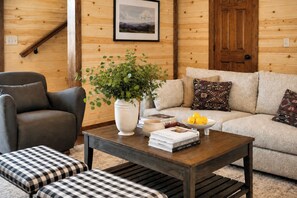 A cozy living room with a sofa, armchair, coffee table, and a potted plant. - Cloud's Rest | Luxury Estate • Pool & Pavilion (Sevierville)