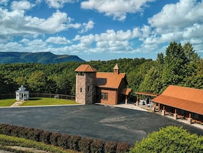 Eine Lodge mit einem Steinturm, einem Holzhaus und einem überdachten Bereich mit Bänken.