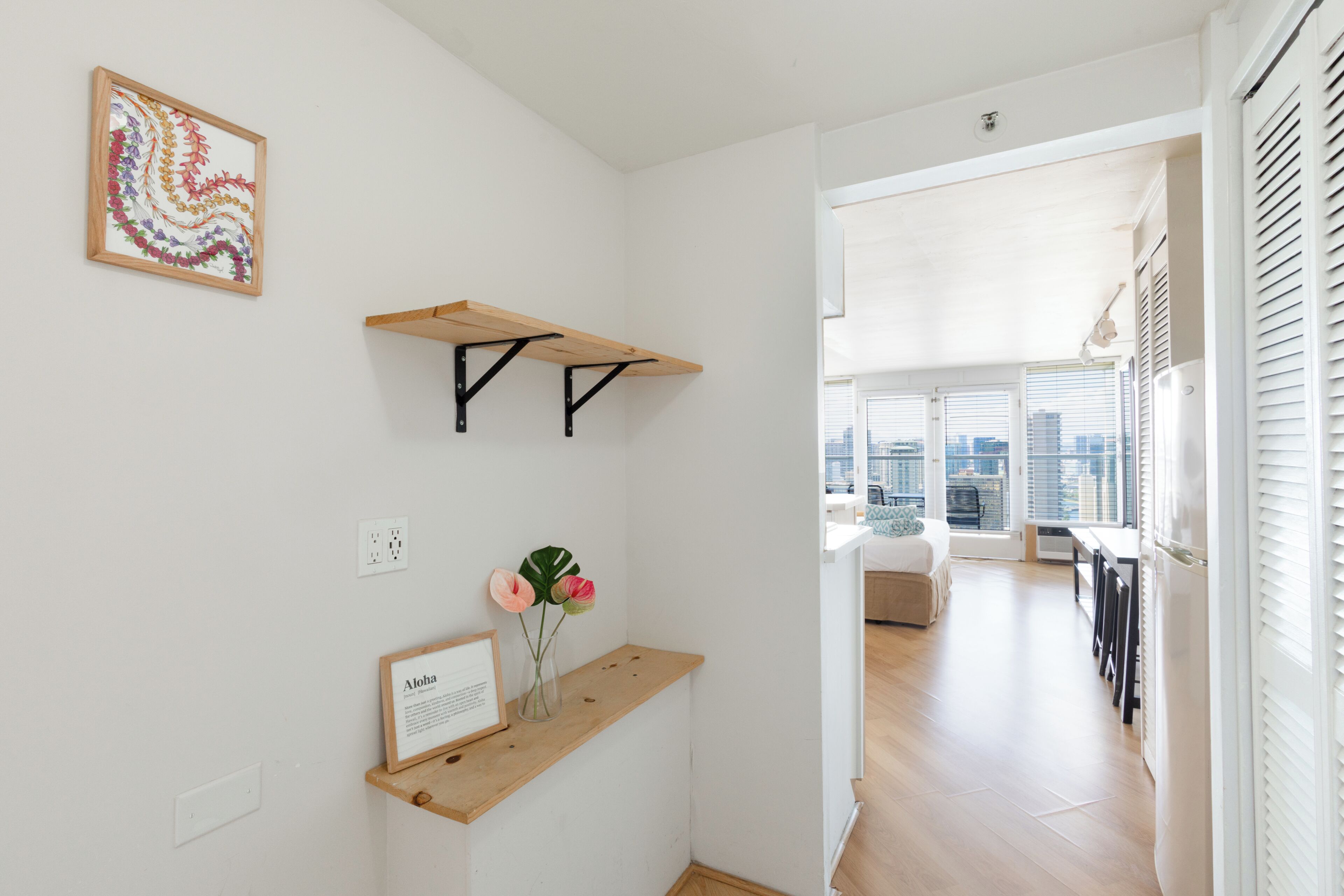 Un intérieur moderne avec un banc en bois, un certificat encadré et une œuvre d’art accrochée au mur.