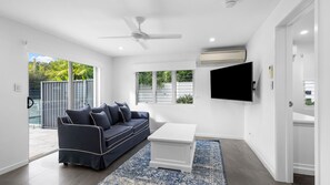 Una sala de estar moderna con sofá, mesa de centro y televisor.