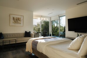 A modern bedroom with a large bed, a sofa, a desk, and a TV. - Hollywood Hills Private Oasis with amazing views (Los Angeles)