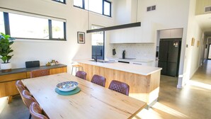 Une cuisine moderne avec un îlot central, une table à manger en bois et des chaises.