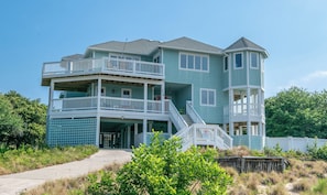 A multi-story building with a balcony, a staircase, and a gated entrance. - Sound Views, Elevator, Pool, Hot Tub, Pets OK, Flex Stays! (Duck)