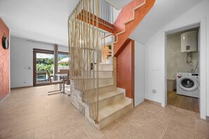 Ein modernes Interieur mit Treppe, Essbereich und Waschraum.