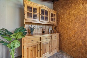A wooden cabinet with glass doors and drawers, a potted plant, and a stone floor. - Villa Kaiserwald by Istrabook (Pula)