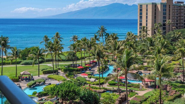 A resort with a pool, palm trees, and a view of the ocean. - 🌊 Hokulani 746 Penthouse with Unobstructed Ocean Views - Special Intro Rates! (Lahaina)