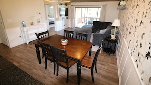 A dining area with a wooden table and chairs, a fireplace, and a television. - Stunning 2 Bdrm/2 Bath Pointe Royale Resort & Golf (Branson)
