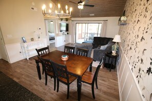 A dining area with a wooden table and chairs, a fireplace, and a television. - Stunning 2 Bdrm/2 Bath Pointe Royale Resort & Golf (Branson)