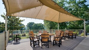An outdoor deck with wooden furniture and a large canopy. - Stunning 2 Bdrm/2 Bath Pointe Royale Resort & Golf (Branson)