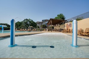 A swimming pool with water jets, lounge chairs, and a covered seating area. - Stunning 2 Bdrm/2 Bath Pointe Royale Resort & Golf (Branson)