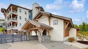 A multi-story building with a covered entrance, balconies, and a stone foundation. - Ski-In/Ski-Out Luxury with Year-Round Resort Amenities (Ludlow)