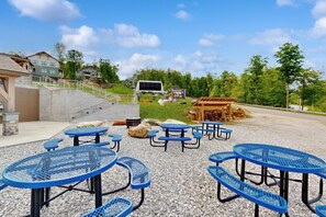 Outdoor seating with tables and benches, a small shelter, and a staircase leading to a building. - Ski-In/Ski-Out Luxury with Year-Round Resort Amenities (Ludlow)