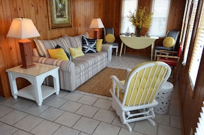 A cozy room with a striped sofa, two side tables with lamps, a white chair, and a small table with a vase. - Ina's Place - Second Row in Garden City Beach (Garden City)