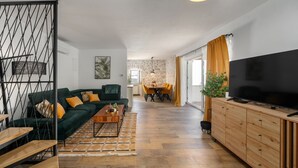 Ein modernes Wohnzimmer mit einer Couch, einem Couchtisch, einem Fernseher und Holzschränken.