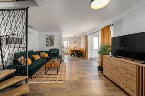 Ein modernes Wohnzimmer mit einer Couch, einem Couchtisch, einem Fernseher und Holzschränken.