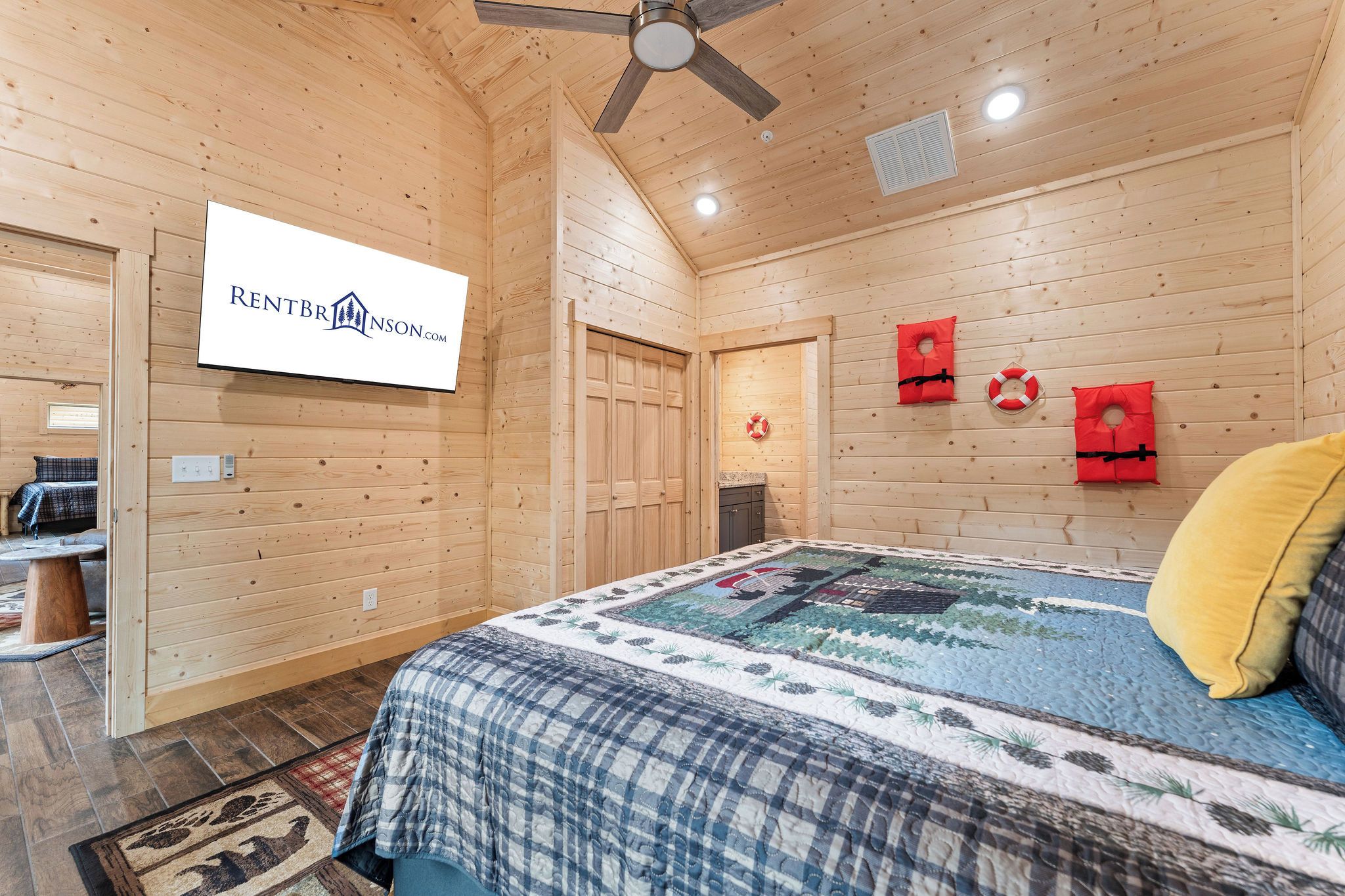 Ein Interieur einer Holzhütte mit einem Bett, einem Deckenventilator und einem Schild an der Wand.