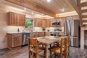 Ein Holzblockhaus-Interieur mit Küche, Esstisch und Stühlen.