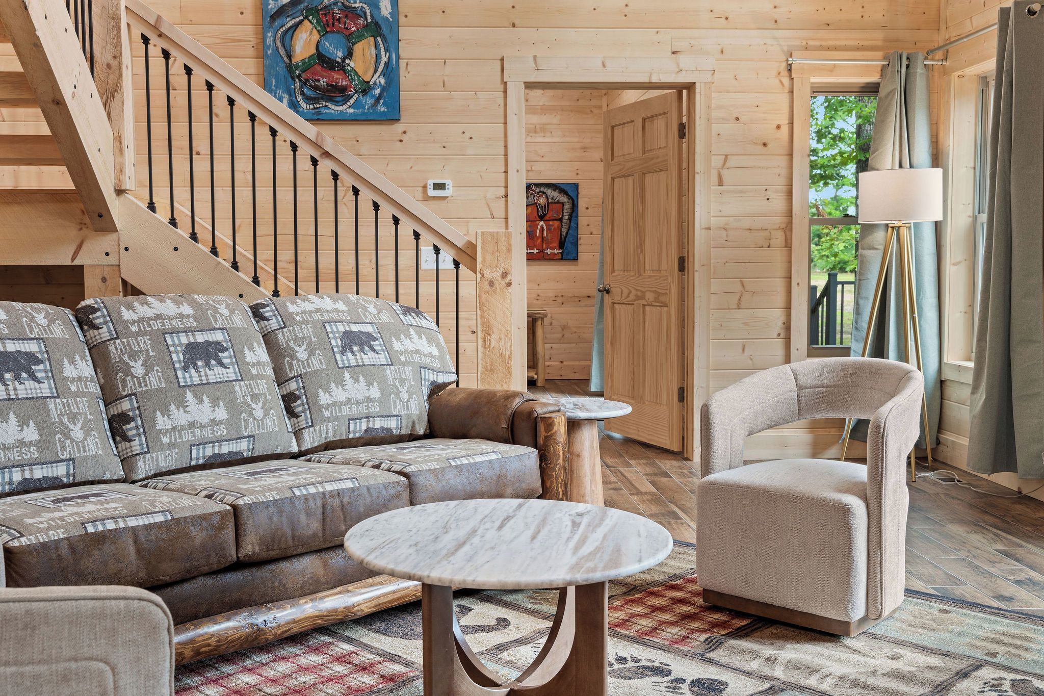 A wooden interior with a sofa, a round table, and a chair.