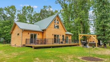 A log cabin with a deck and a covered outdoor area.