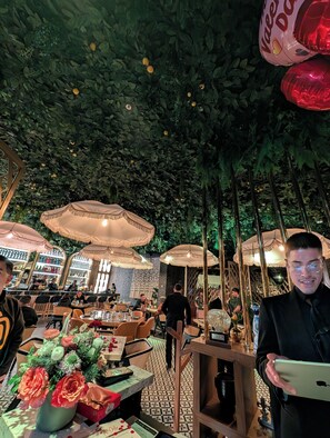 Un espace de restauration intérieur avec des tables, des chaises et des parasols.