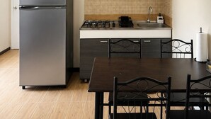 Uma cozinha compacta com geladeira, micro-ondas, fogão, pia e espaço para refeições.