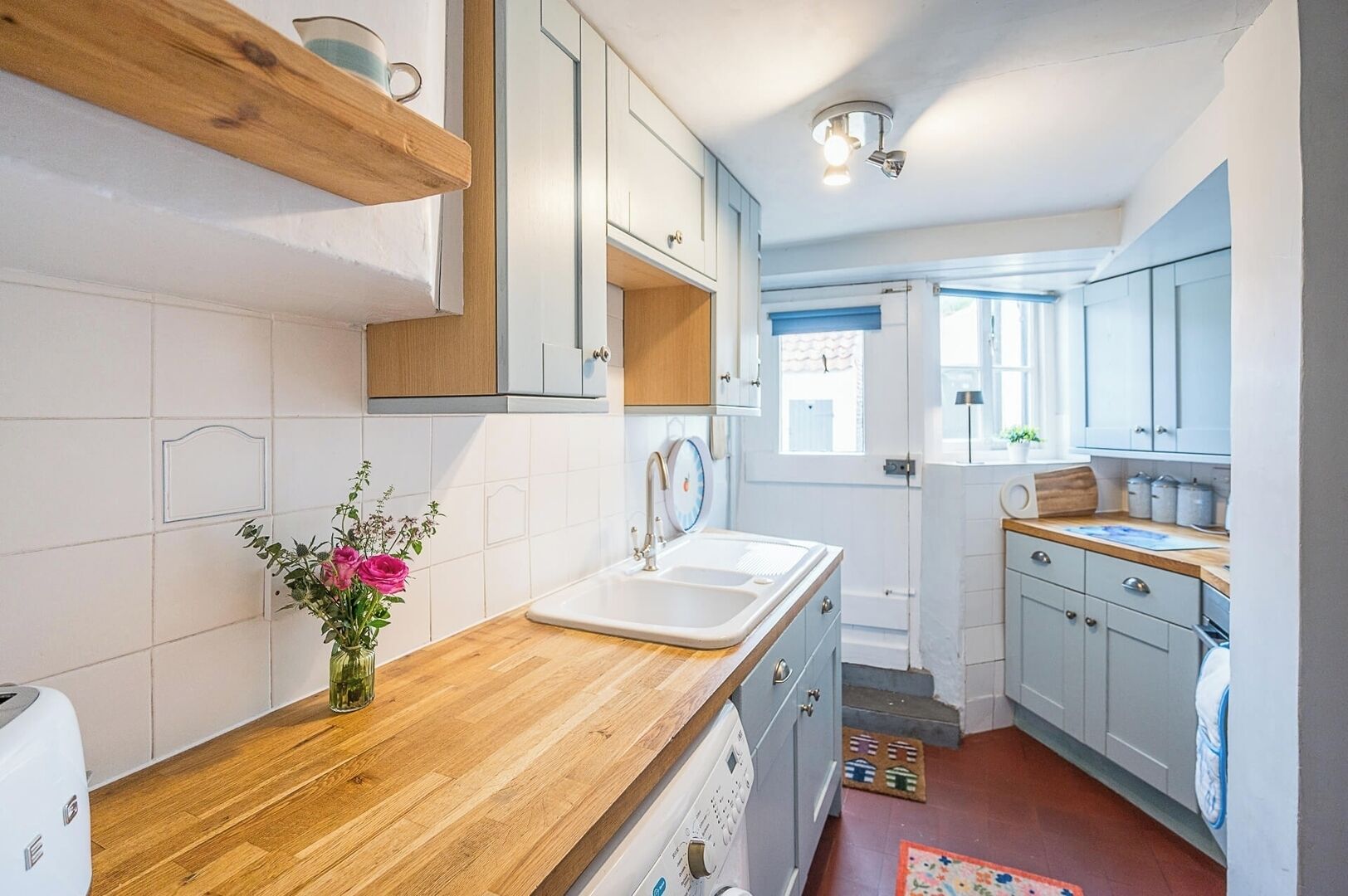 A modern kitchen with wooden countertops, a sink, and cabinets.