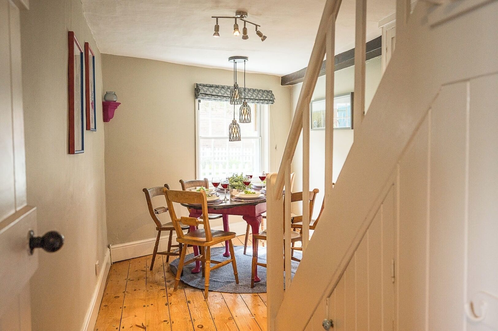 A dining area with a wooden table, chairs, and a chandelier.