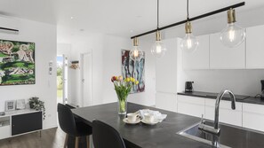 A modern kitchen with a central island, pendant lighting, and a view of the outdoors. - VillaVilla 969 - Marielyst, Lolland/Falster/møn (Væggerløse)