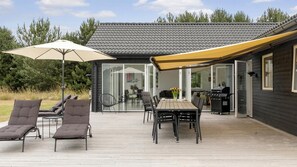 An outdoor patio with a table and chairs, a grill, and a covered seating area. - VillaVilla 969 - Marielyst, Lolland/Falster/møn (Væggerløse)