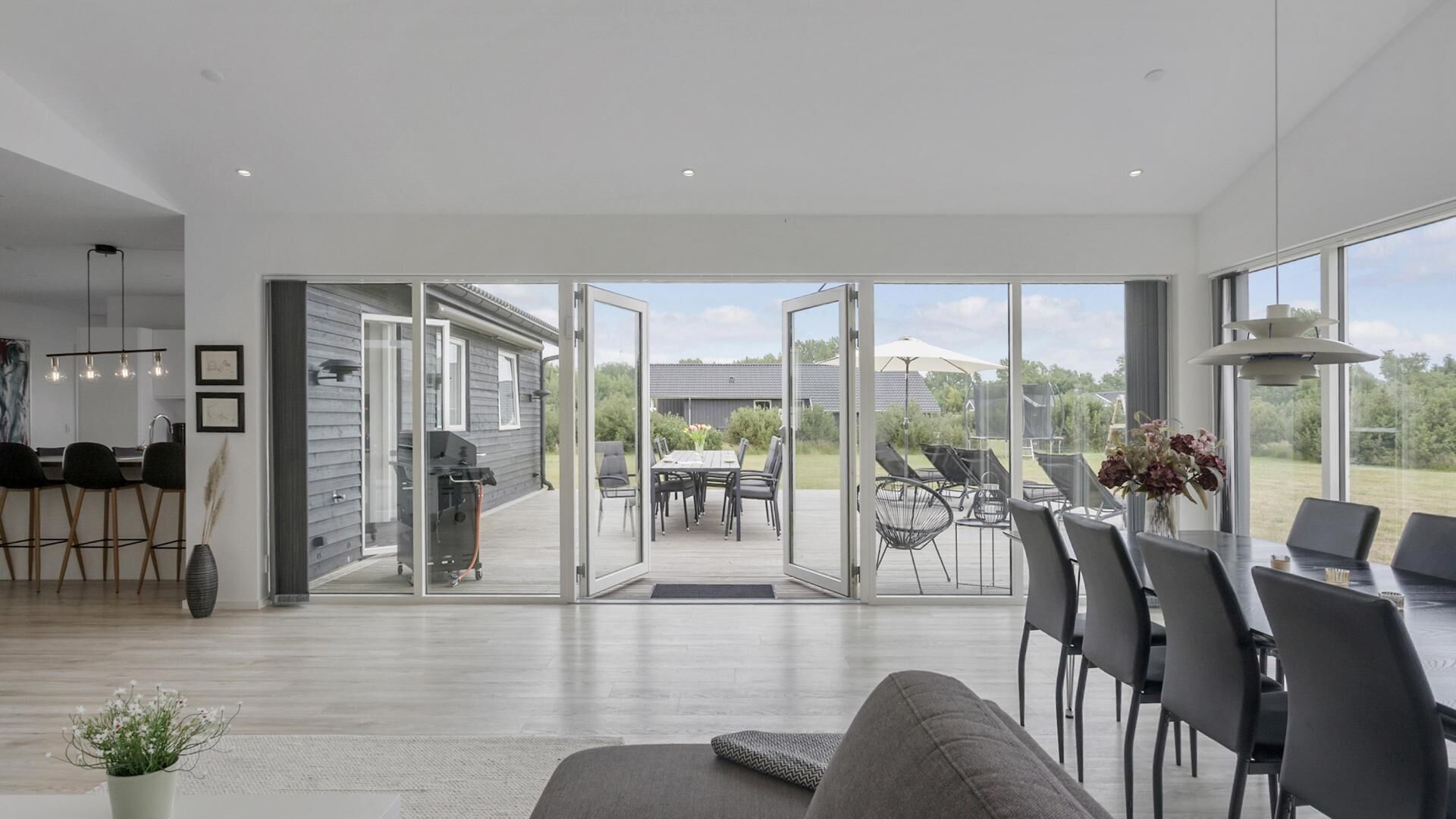 Een modern interieur met een eethoek, keuken en open terras.