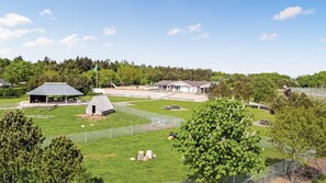 A park with a pavilion, a small shed, and a fenced area with picnic tables.