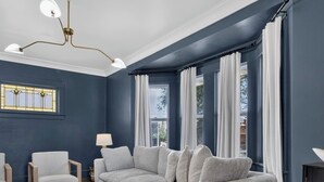 Ein stilvolles Wohnzimmer mit einem Ecksofa, einem runden Couchtisch und einer Kronleuchter.