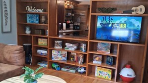 A living room with a wooden bookshelf, a television, and a round coffee table with a plant.