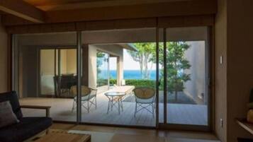 A room with a sliding glass door leading to an outdoor deck with a table and chairs.