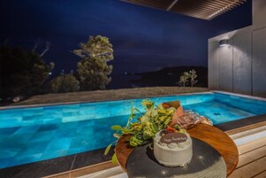 Escena junto a la piscina con una mesa que presenta un pastel y follaje.