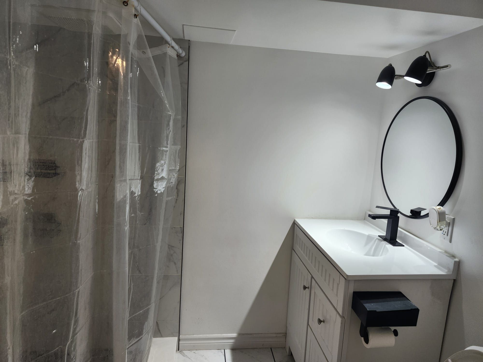 A bathroom with a shower, a sink with a mirror, and a towel rack.