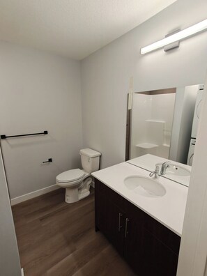 Un baño moderno con inodoro, lavabo y espejo.