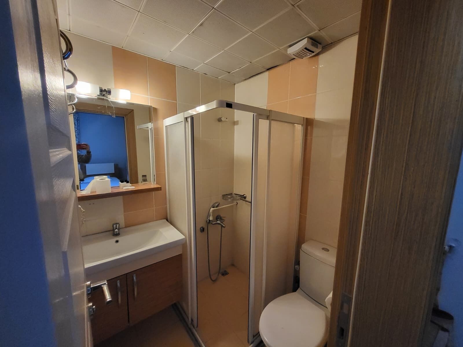 Pieni kylpyhuone, jossa on suihku, wc ja pesuallas.