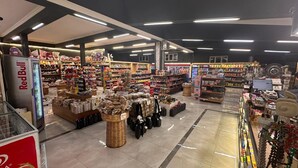 Uma loja ampla com vários corredores e prateleiras repletas de uma grande variedade de produtos.