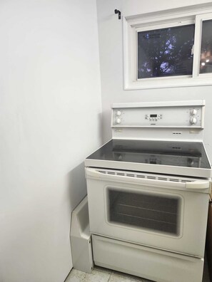 Un four blanc doté d’un panneau de commande et d’une fenêtre située au-dessus.