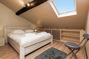 A bedroom with a loft-style ceiling, a bed, a desk, and a chair. - Upstays Lions Duplex 45m² Suquet Port (Cannes)