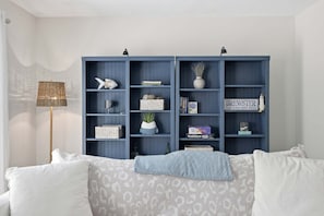 A room with a bed, a blue bookshelf, and a floor lamp. - Brewster townhouse near beach & golf (Brewster)
