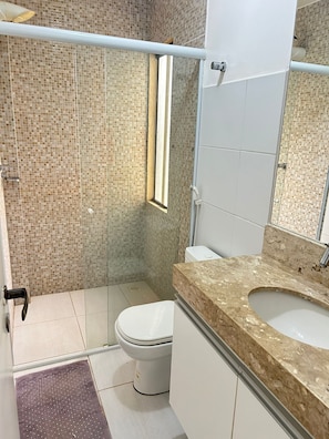 Une salle de bain avec une douche, des toilettes et un lavabo.
