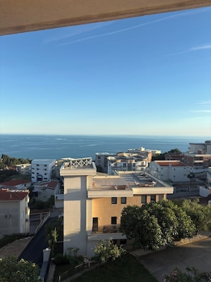 Ein Küstenwohngebiet mit Gebäuden, wolkenlosem Himmel und dem Meer im Hintergrund.